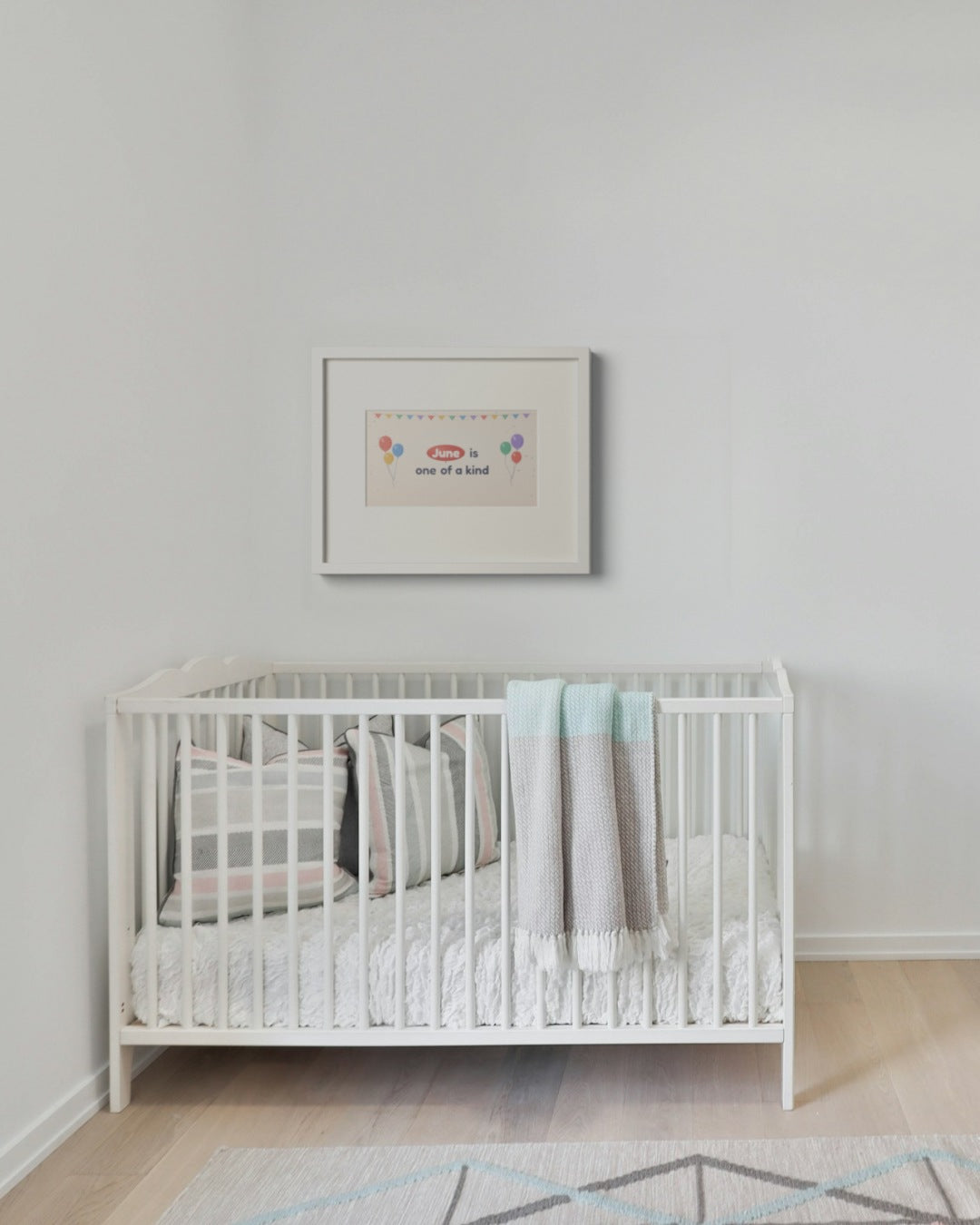 Quoteplume Kids frame above a crib with a balloon-party affirmation